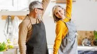 Franke und Bornberg Rating Riester-Rente 2. Schicht - älteres Paar tanzt glücklich in der Küche beim Kochen