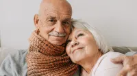 Franke und Bornberg Rating Pflegerentenversicherung - älteres Paar sitzt sich umarmend auf dem Sofa