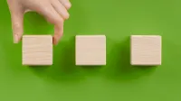 Franke und Bornberg Rating Bündelversicherungen Kompositversicherung - Hand setzt Bauteile zusammen