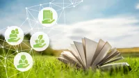 Ein offenes Buch auf einer grünen Wiese - Glossar zur Nachhaltigkeit