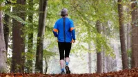Älterer Mann joggt durch den Wald in einer Totalen von hinten - Betriebsrentenstärkungsgesetz BRSG
