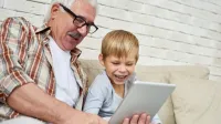 Großvater mit Enkel vor einem Tablet - So veränderte das BRSG die betriebliche Altersvorsorge