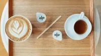 Zwei Tassen Kaffe nebeneinander, eine mit, die andere ohne Milch, angeordnet als Prozent-Symbol - Brutto-Netto-Spread in der BU Versicherung