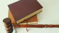 Ein Gesetzbuch mit einem Richterhammer - Bu-Leistungspraxis Prozessquote und Gutachten