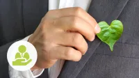Eine Hand halt ein Pflanzenblatt, das wie ein Herz geformt ist - Nachhaltigkeit und Governance