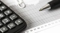 Taschenrechner und Stift auf einer Tabelle - Was bringen PRIIP-Verordnung und Basisinformationsblätter wirklich? -