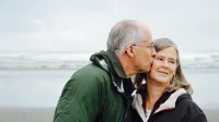 Porträt ein älteres Paar am Strand vor Wellengang - Was bedeutet der Rentenfaktor?
