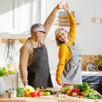 Franke und Bornberg Rating Riester-Rente 2. Schicht - älteres Paar tanzt glücklich in der Küche beim Kochen