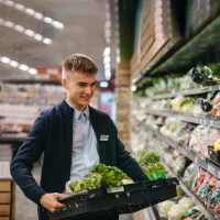 Franke und Bornberg Rating Erwerbsunfähigkeitsversicherung - Mitarbeiter trägt schwere Kiste im Supermarkt
