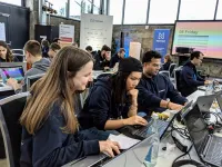 Teilnehmerinnen des Hackathon sitzen an Laoptops in einer Halle - Hacknext 2019